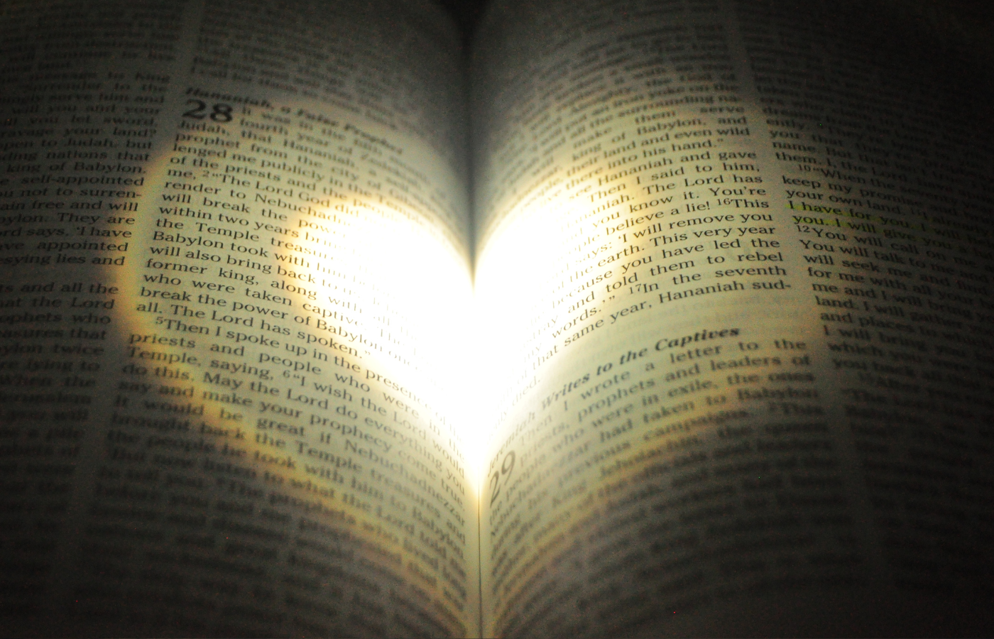 Torch shined heart on open Bible